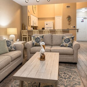 A living room with a sofa, a coffee table, and a decorative bird sculpture.