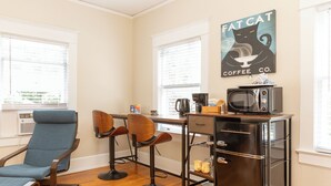 A kitchen with a bar area, a microwave, and a coffee station.
