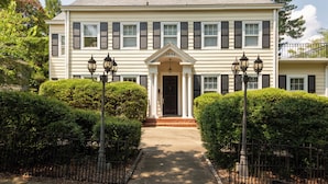 A two-story house with a symmetrical facade, a central entrance with a door, and a number "1006" above the door.