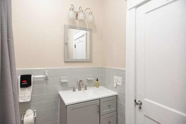 A bathroom with a white sink, mirror, and towel rack.
