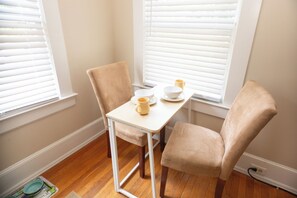 Un comedor con una mesa, sillas, un cuenco, una taza y un plato.