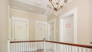 A staircase with white railings and a chandelier.