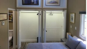 A bedroom with a bed, a closet with a sliding door, and two framed pictures on the wall. - Tropical Paradise studio #3 (Tampa)