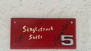 Un cartello rosso con la scritta "Singletrack Suite" e il numero 5 su una parete strutturata.