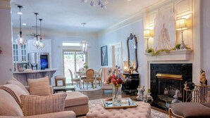 A living room with a fireplace, a dining area, and a kitchen.