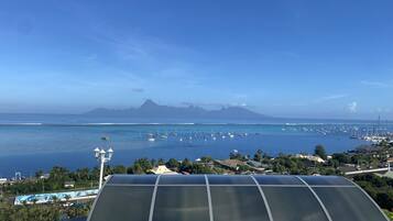A coastal view with a marina, a mountain in the background, and a solar panel on a building.