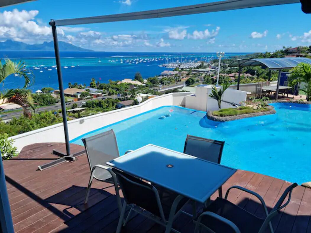 Une piscine avec vue sur l’océan et le port de plaisance.