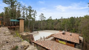 Un resort con piscina, restaurante y vistas al bosque circundante.