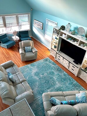 A living room with a sectional sofa, a chair, a TV stand, and a rug.