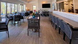 A spacious restaurant with high ceilings, large windows, and a modern bar area. - Estero Resort Condo w/ 2 Pools & Tennis Center! (Estero)