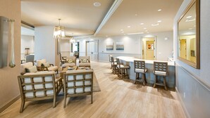 A spacious living room with a dining area, featuring wooden furniture and a large mirror. - Estero Resort Condo w/ 2 Pools & Tennis Center! (Estero)