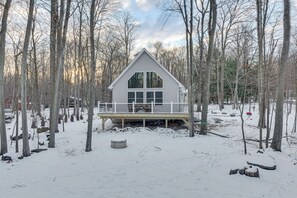 A cabin with a deck, surrounded by trees and snow. - Hike & Ski: Pocono Lake Home w/ Community Perks! (Pocono Lake)