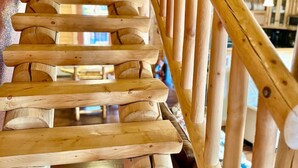 A wooden staircase with a handrail, leading to an upper floor.