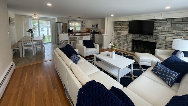 A modern living room with a sofa, coffee table, and fireplace. - Private Falmouth home perfect for family fun - hot tub, fire pit, and game room! (Falmouth)