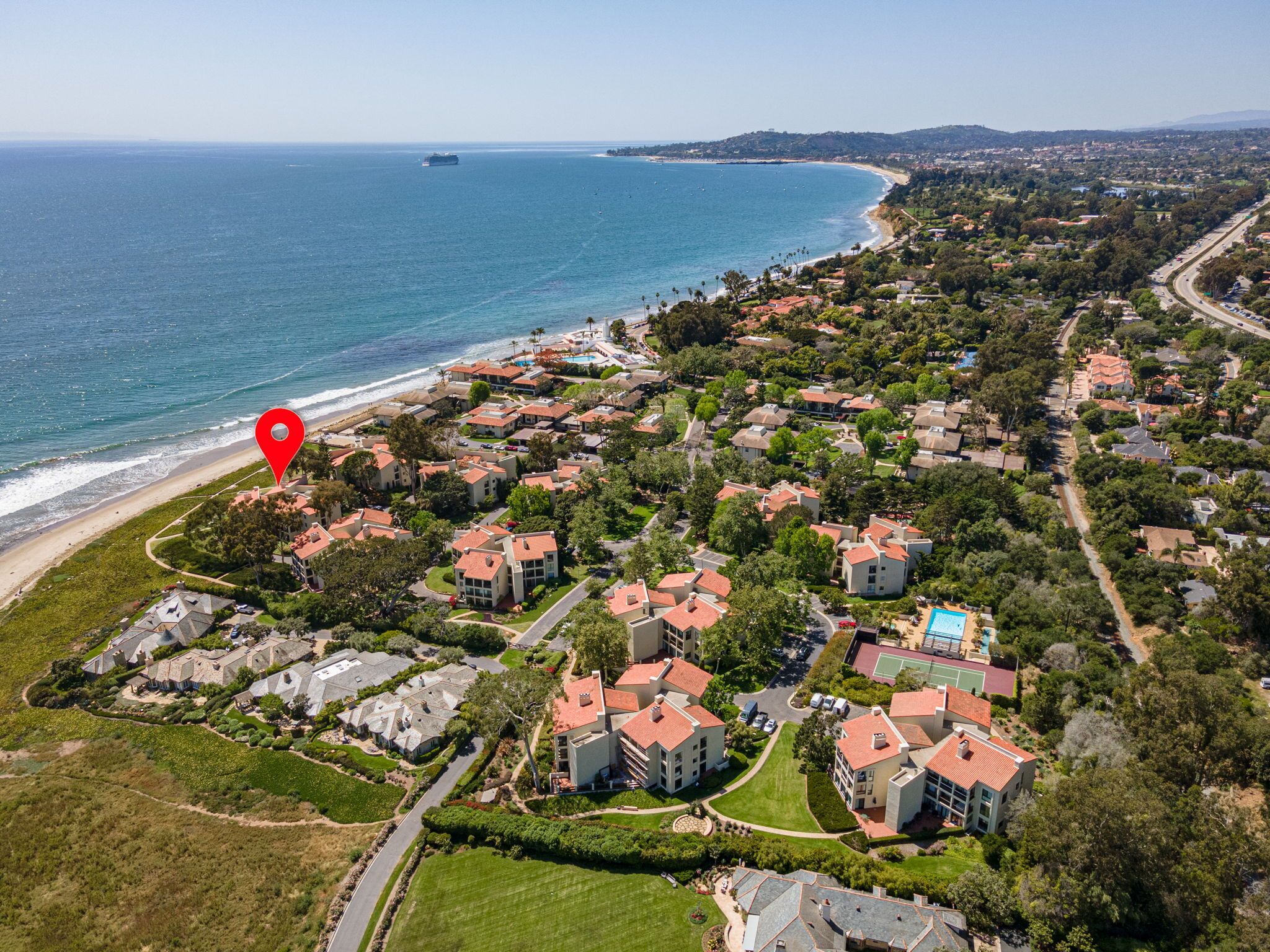 Vista aérea de una zona residencial costera con casas, una playa y una gran masa de agua.