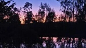 A campfire with chairs arranged around it, set against a backdrop of trees and a twilight sky. - Deluxe Leaf Bell Tent (Clydesdale)