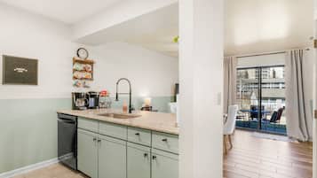 Una cocina moderna con un lavamanos, armarios y un reloj en la pared.