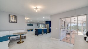 A spacious living area with a central island, a dining table, and a bench. - MODERN HOME WITH HEATED POOL! CLOSE TO SAWGRASS MILLS MALL! FLEXIBLE CHECK IN 
  (Sunrise)
