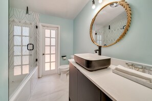 A bathroom with a modern design, featuring a large mirror, a white sink, and a shower area. - MODERN HOME WITH HEATED POOL! CLOSE TO SAWGRASS MILLS MALL! FLEXIBLE CHECK IN 
  (Sunrise)