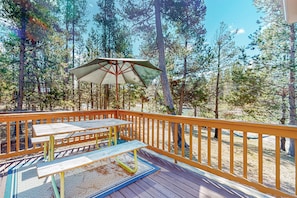 Enjoy al fresco dining on the deck surrounded by a serene forest environment.