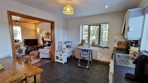 A compact living space with a dining area, kitchenette, and a seating area with a TV.