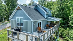 A two-story house with a deck and a covered outdoor seating area. - Brand new luxury home with a magnificent view , and luxurious hot-tub (Townsend)