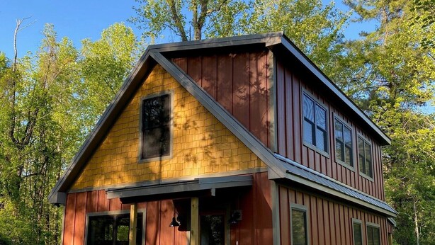 Il s’agit d’un bâtiment en bois à deux étages, doté d’un toit à pignon, d’un porche à l’avant et d’un petit garage attenant.