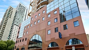 Um edifício moderno com grandes janelas e um arco imponente.