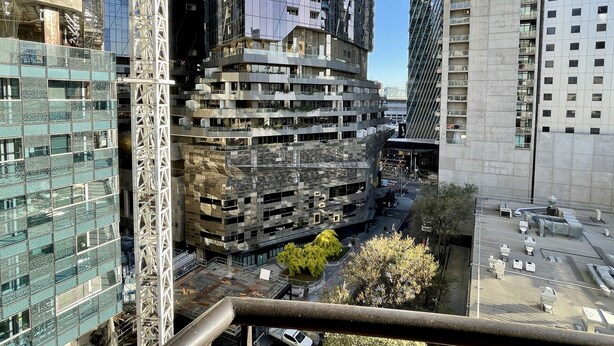 Um edifício alto com vários andares, janelas grandes e varandas.