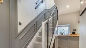 A modern kitchen with grey cabinets, a wooden countertop, and a window. - Cottage in the heart of the Peak District (Matlock)