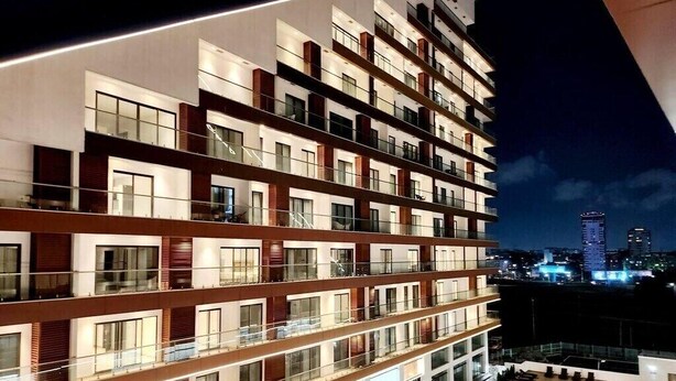 Un hôtel à plusieurs étages doté de balcons, d’une piscine sur le toit et offrant une vue panoramique sur la ville.