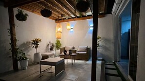 An outdoor patio with a sofa, a table, and potted plants. - Hermosa Y Divertida Casa, Cerca A LA Playa Y AL Centro Histórico (Santa Marta)