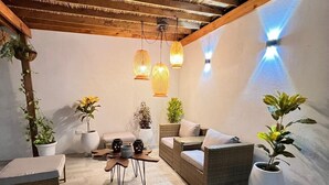 A cozy patio area with wicker furniture, potted plants, and hanging lanterns. - Hermosa Y Divertida Casa, Cerca A LA Playa Y AL Centro Histórico (Santa Marta)