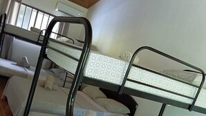 Un dormitorio con literas, un sofá y una ventana.