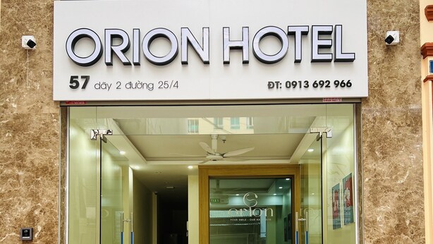 The exterior of Orion Hotel with a reception area visible through the glass doors. - Orion Hotel Halong (Hong Gai)