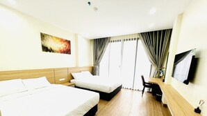 A hotel room with two beds, a desk, a chair, a TV, and a window with curtains. - Orion Hotel Halong (Hong Gai)