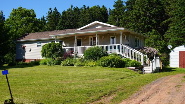A single-story house with a front porch, a small front yard, and a dirt path leading to the front door. - Cozy private cottage with picturesque scenery (New Glasgow)