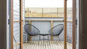 A balcony with two black wire chairs and a small round table. - North Edge Cottage ~ Free Parking, City, Warm (Launceston)