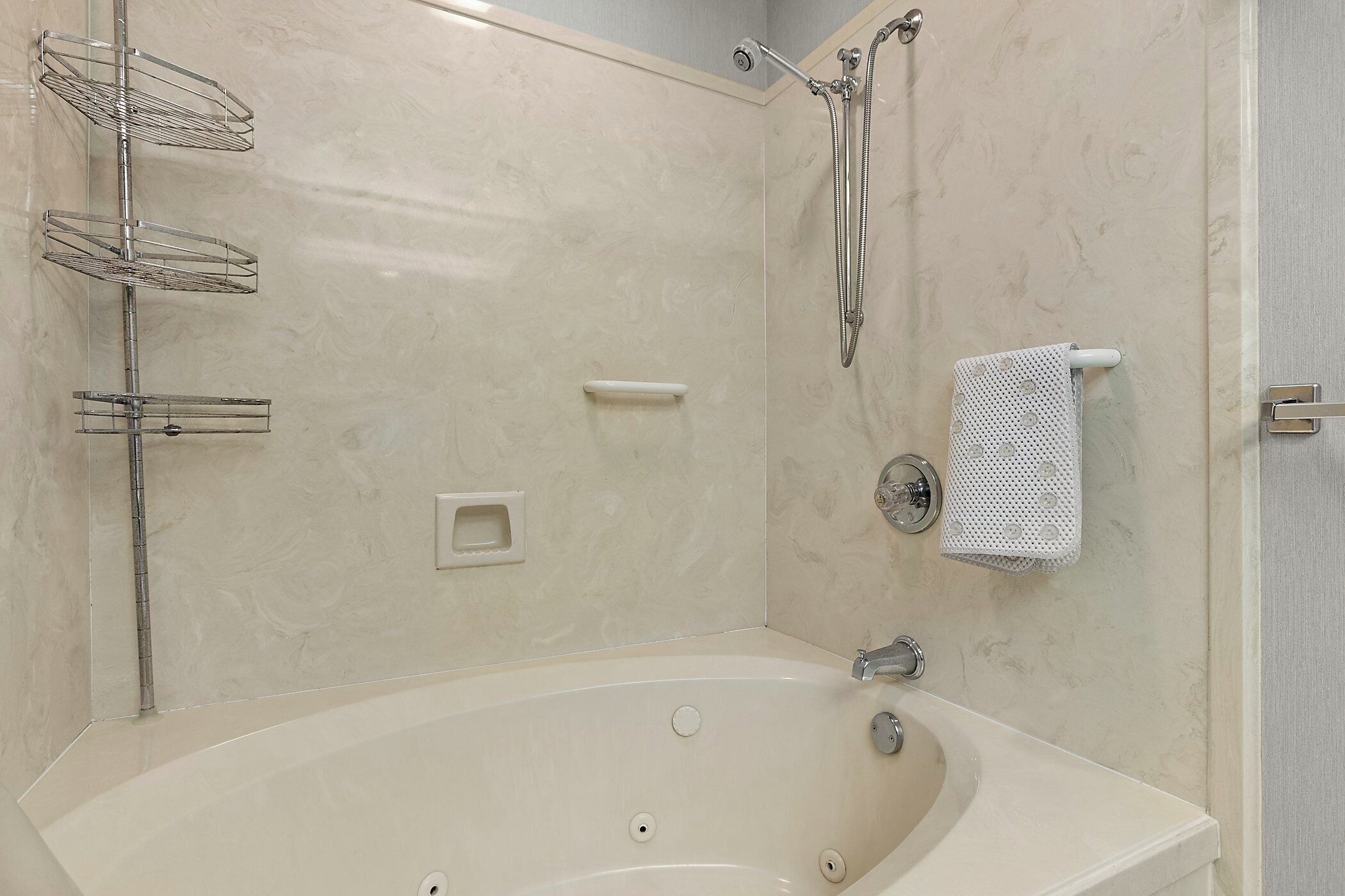 A bathroom with a bathtub, a shower, and a towel rack.