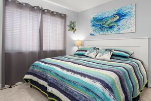 Un dormitorio con cama, cortinas, una lámpara de pared y un cuadro.