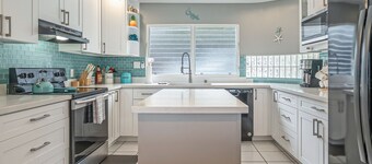 Two-story ocean view home with a furnished patio & deck, washer/dryer, & AC