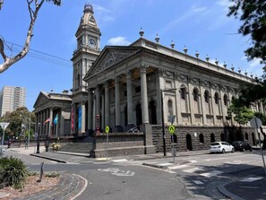 A historic building with classical architecture, including columns and a clock tower. - A Cool Little Hideaway in the Heart of Fitzroy (Fitzroy)
