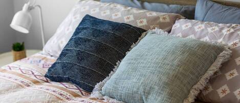 A bed with patterned bedding and three pillows.