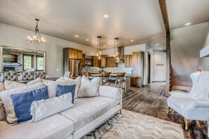 A modern living room with a sofa, a coffee table, and a fireplace. - Whitefish Mountain Escape, 6 Bedroom Sleeps 14, Amazing Views! (Whitefish)