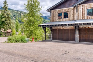 A rustic wooden house with a garage and a covered porch.
