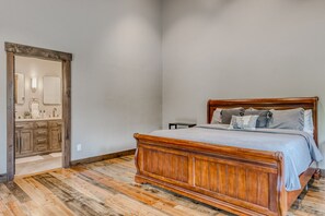 A bedroom with a wooden bed, a nightstand, and a dresser. - Whitefish Mountain Escape, 6 Bedroom Sleeps 14, Amazing Views! (Whitefish)