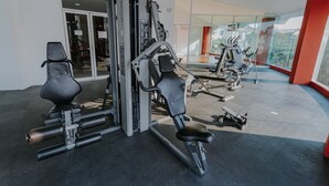 A gym with various exercise equipment, including a leg press machine and a bench press. - Hermoso Depa en la Mejor Zona y Amenidades Únicas (Acapulco de Juárez)