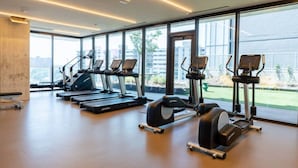 A gym with treadmills, elliptical machines, and weight stations. - Modern Downtown Condo*Rooftop pool*Top Amenities (Austin)