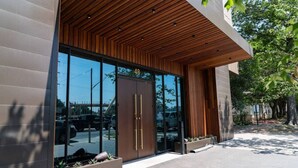 A modern building with a glass entrance, wooden slatted ceiling, and a number "48" sign.