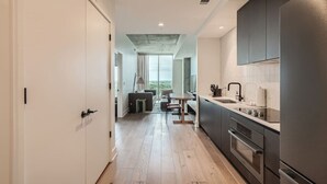 A modern kitchen with a central island, built-in appliances, and a view to a dining area.